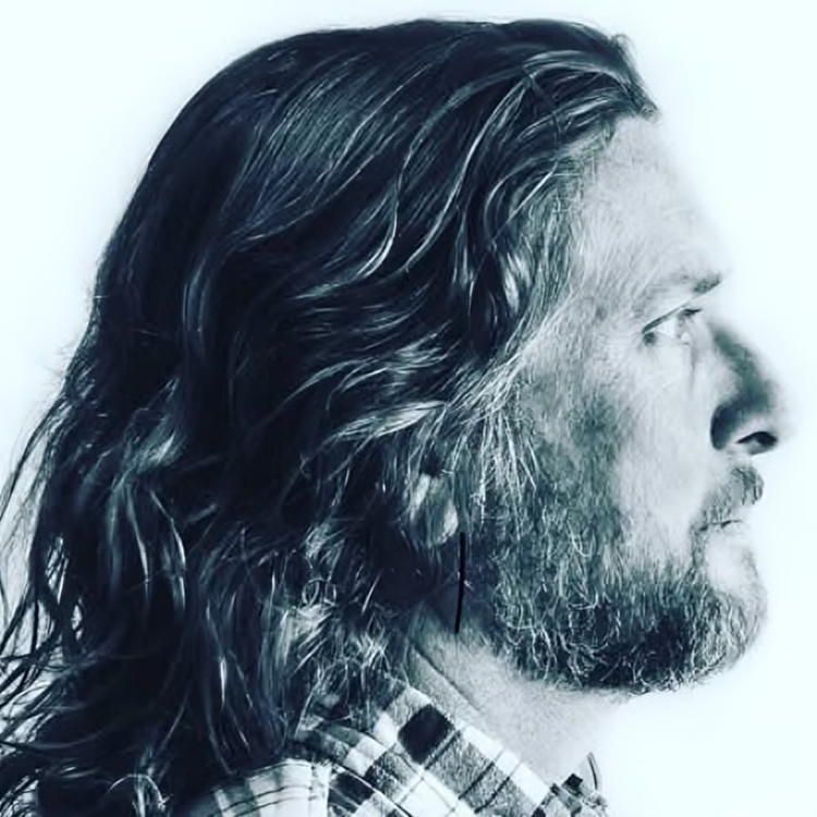 Man with long hair in profile view.