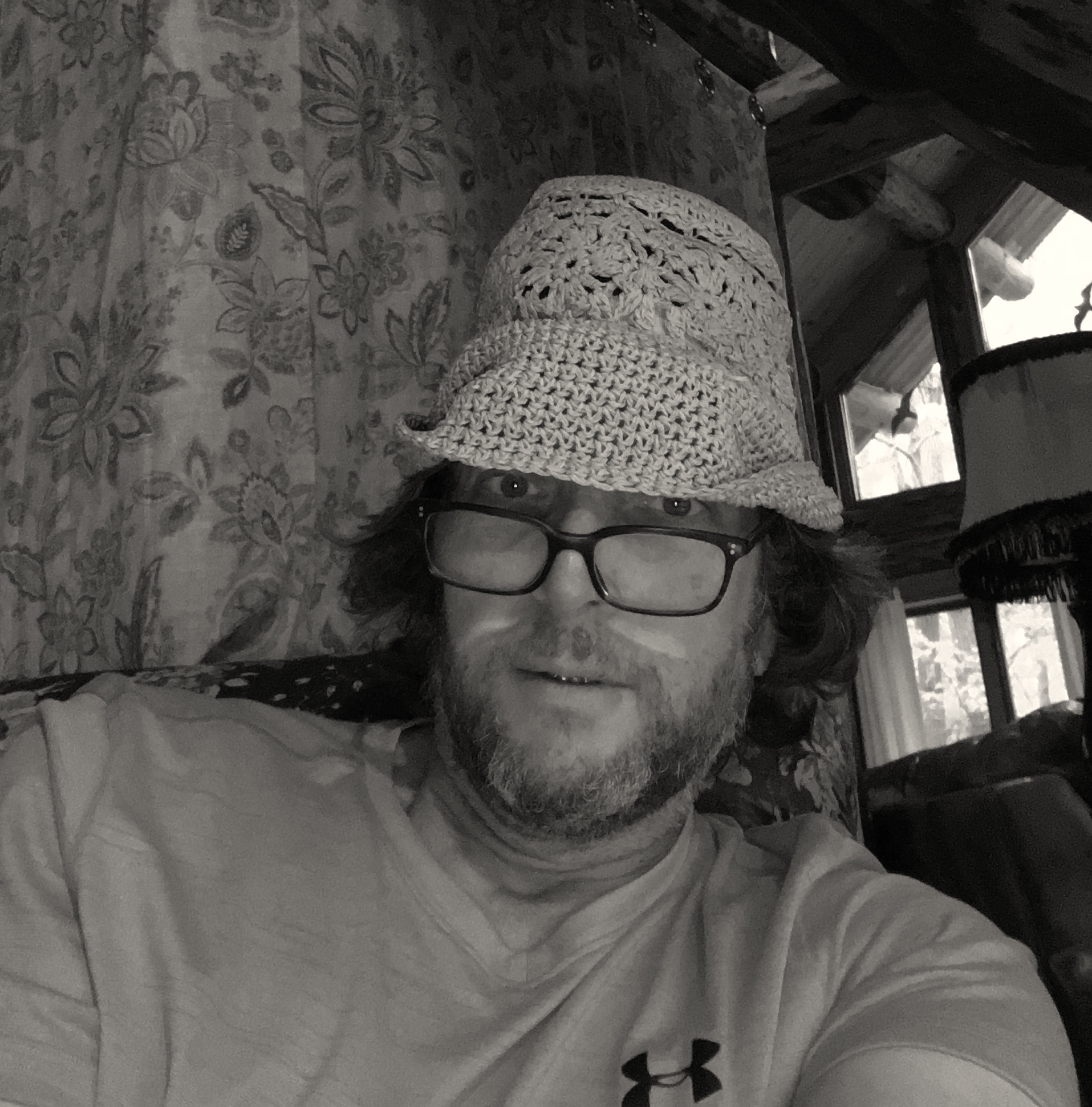 Man wearing glasses and a crochet hat.