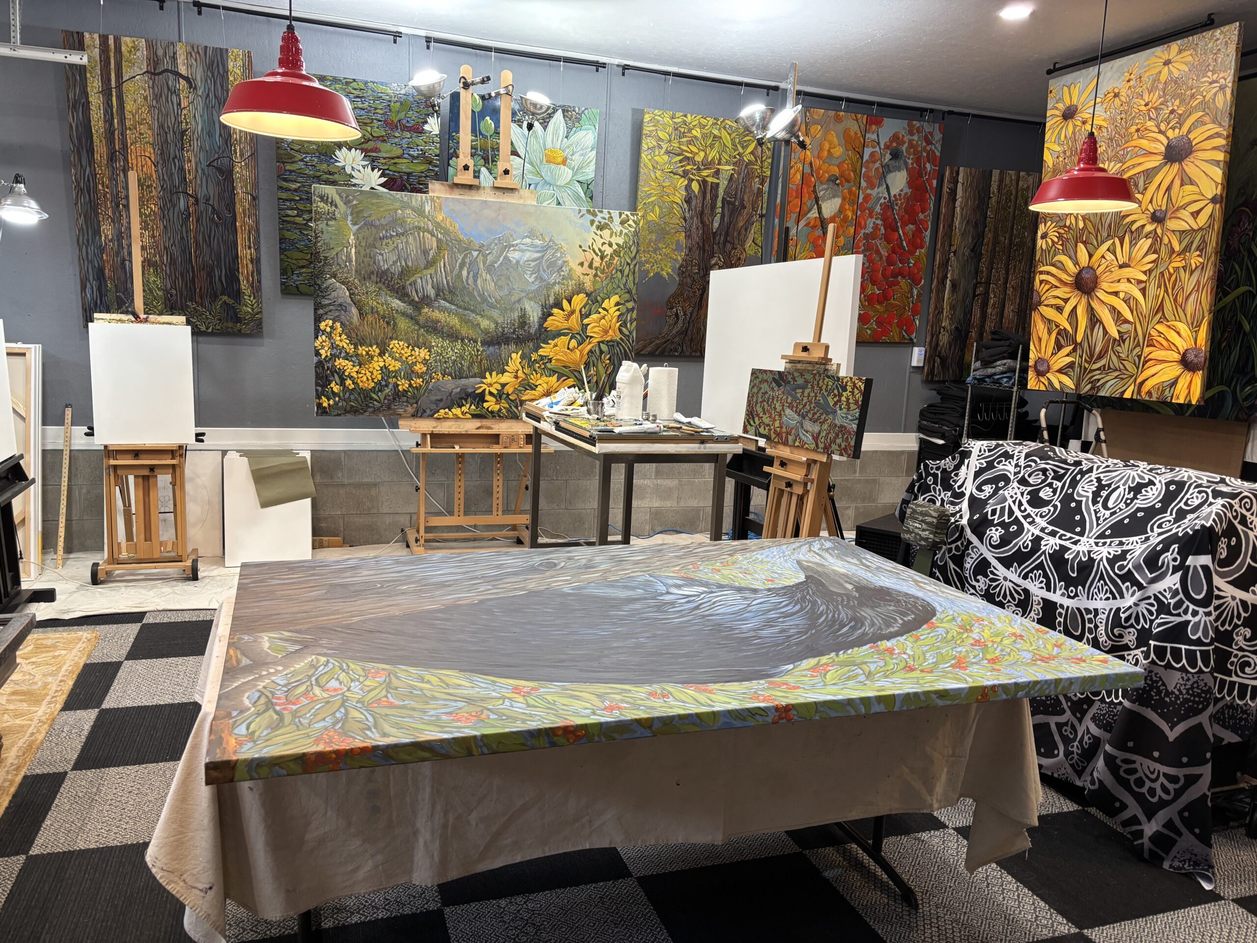 Art studio with vibrant nature paintings displayed.