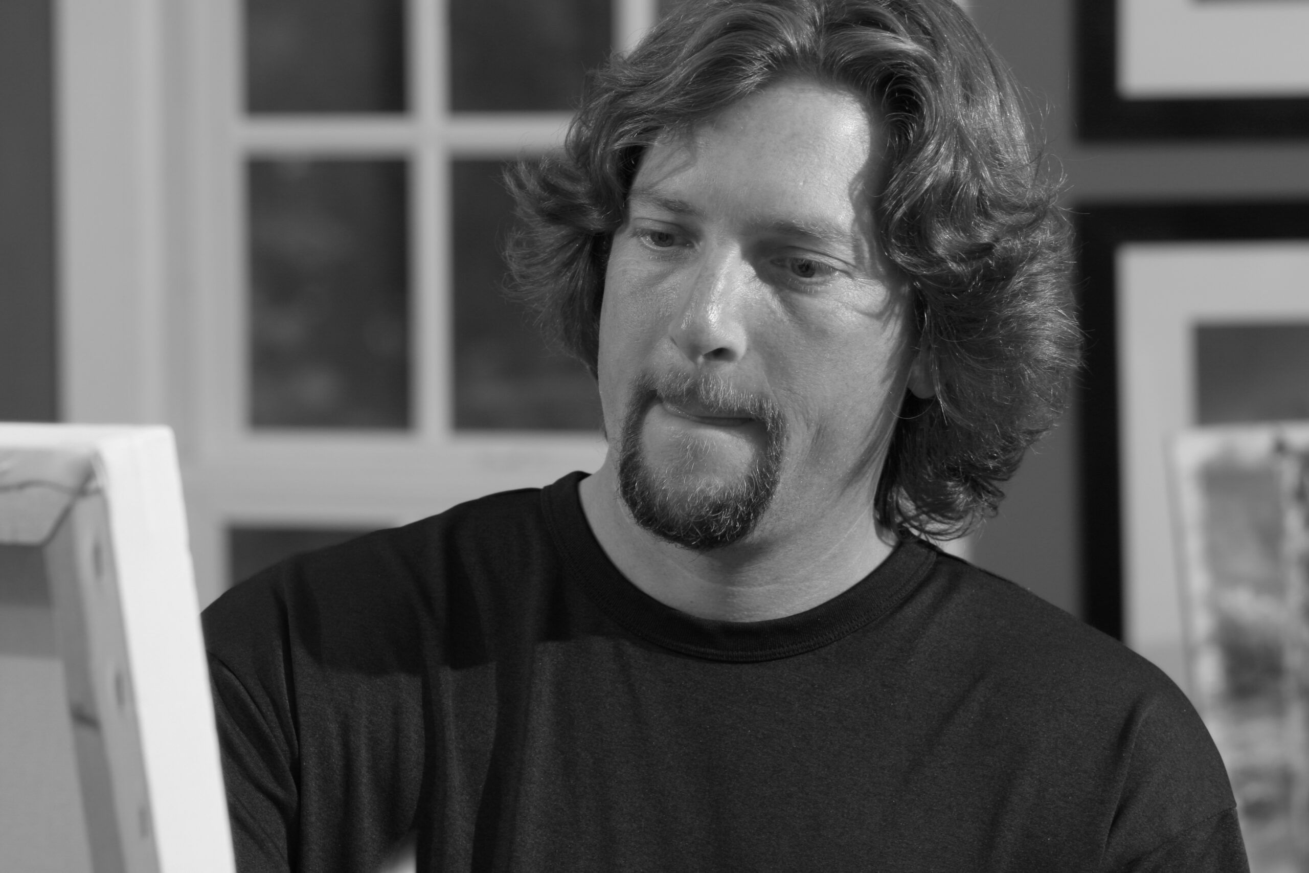 Artist painting on canvas in black and white.